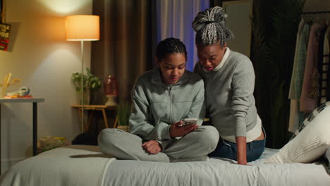 mother supporting daughter in bedroom