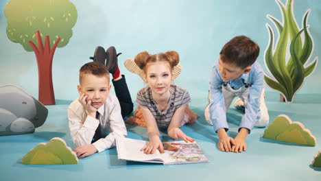 funny children read a book on decorative background. studio shooting of children