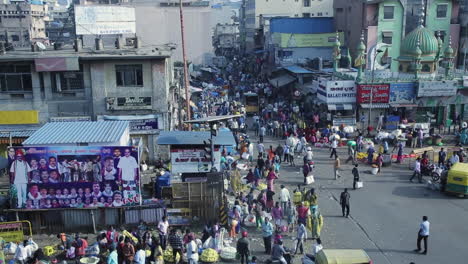 bustling street market in kr market area of bangalore with crowds, shops, and mosque in the background