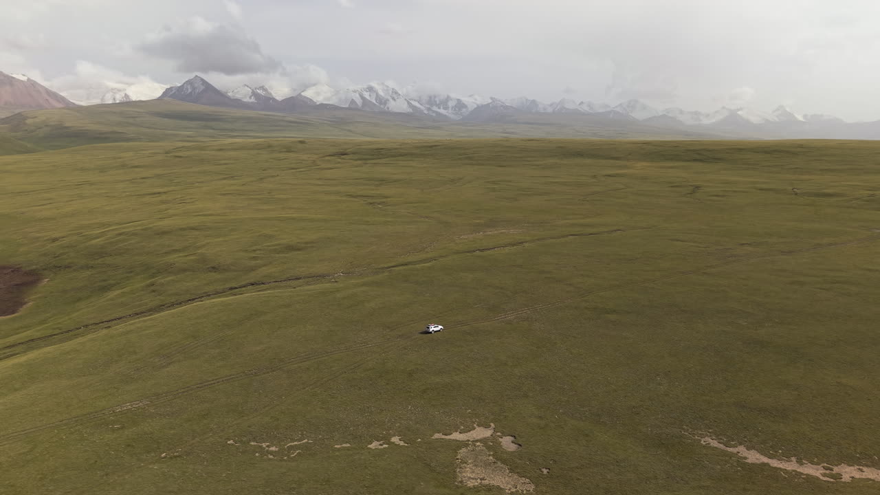 Aerial View Of 4x4 Car Driving On Greenery Terrain In Kyrgyzstan, Central Asia