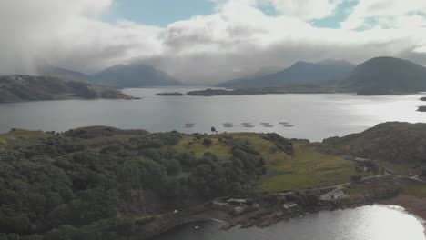 toma aérea de drones del hermoso paisaje escocés en las tierras altas del norte con la bahía del lago y las montañas verdes en el día soleado del reino unido
