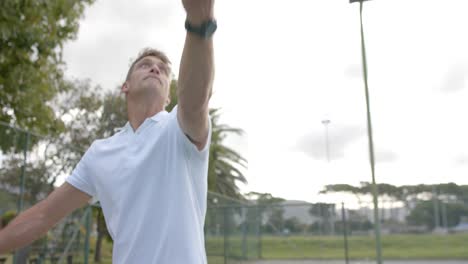 Kaukasischer-Männlicher-Tennisspieler,-Der-In-Zeitlupe-Den-Ball-Auf-Dem-Tennisplatz-Im-Freien-Serviert