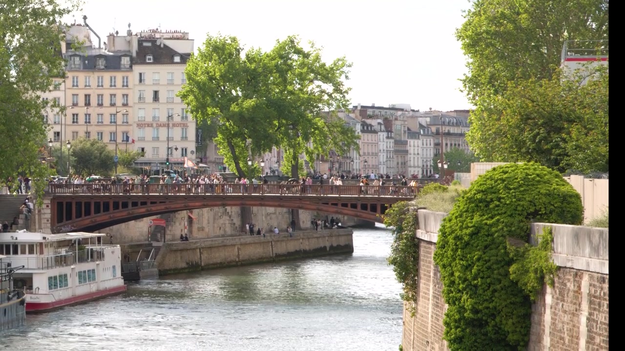 Bidikan lebar pejalan kaki di jembatan Pont au Double dekat Notre Dame di Paris, Prancis
