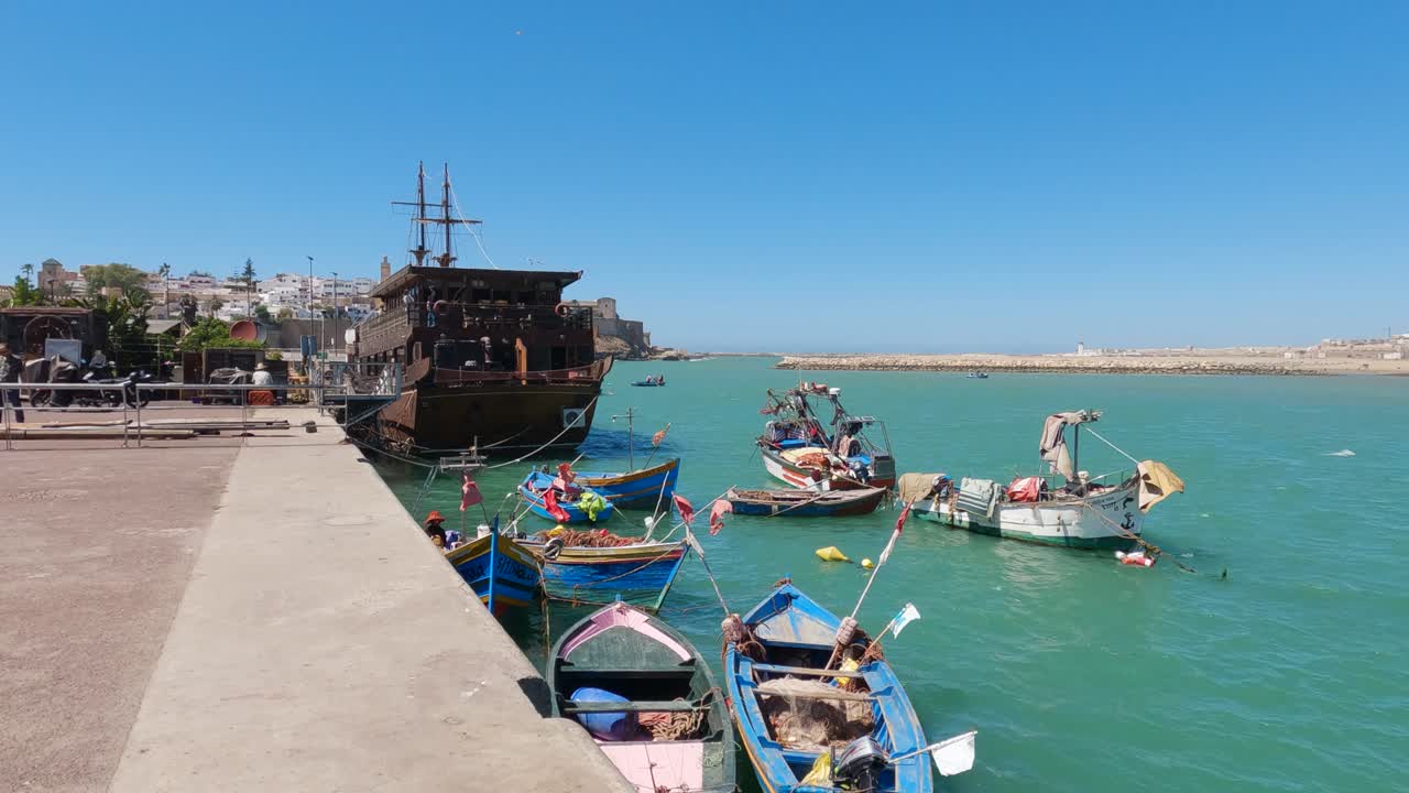 Colorful boats on Rabat's river embankment, clear Moroccan skies