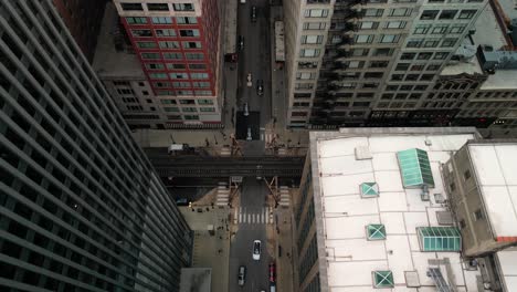 aerial pan of city street and cars and metro train tracks, chicago, illinois - drone 4k