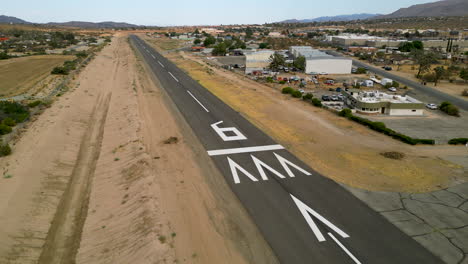 aerial drone shot circling runway numbers showcasing runway at a small general aviation airport and surrounding area