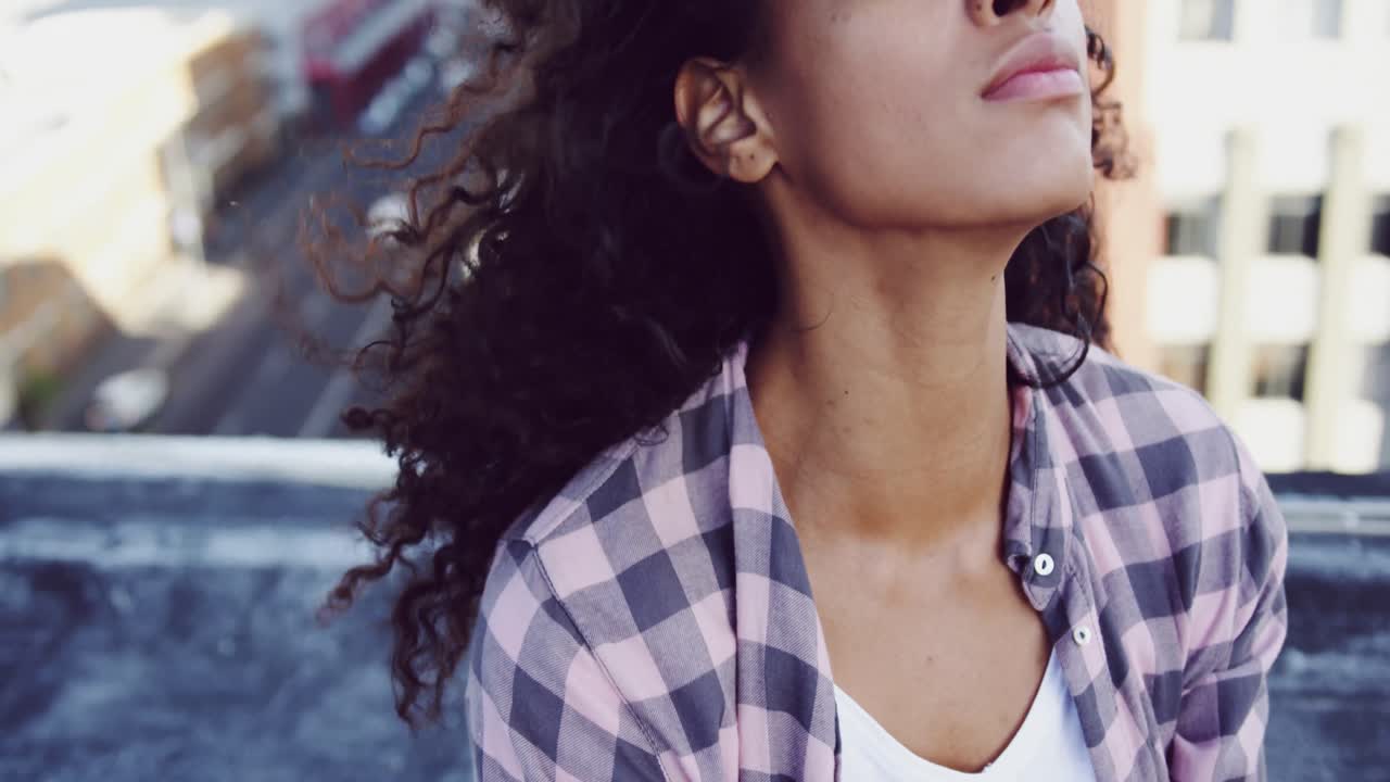 Giovane donna alla moda su un tetto urbano