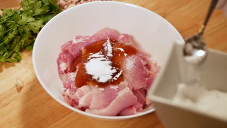 Adding-Salt-into-Pork-White-Marinate-Bowl,-Close-Up