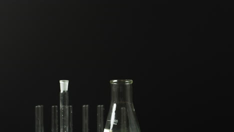 Colored liquids in flasks and tubes for science and education on black background.