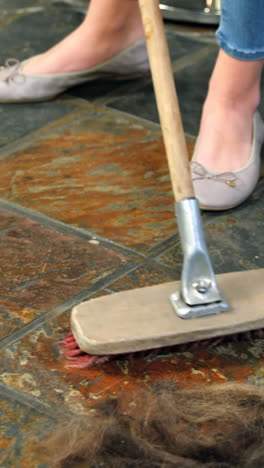 hairdresser cleaning the waste on floor