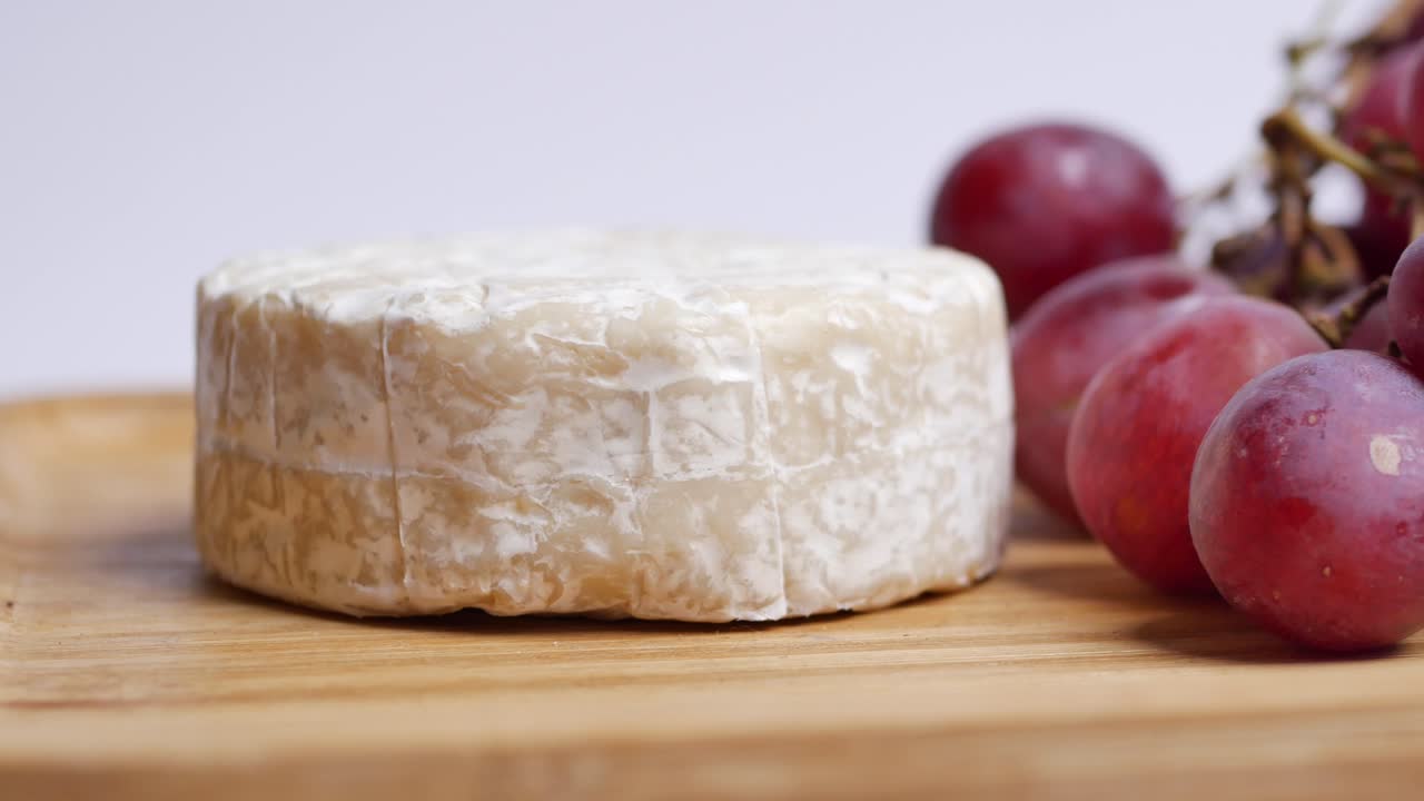 queso camembert y uvas en tablero de madera
