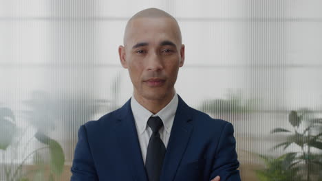 portrait young successful businessman arms crossed looking confident hispanic entrepreneur professional wearing suit slow motion