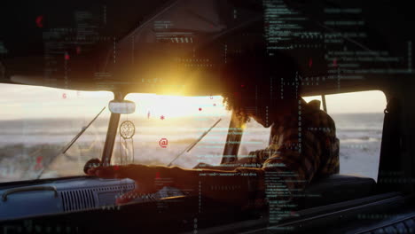Digital code overlay on silhouette of person in van during sunset animation