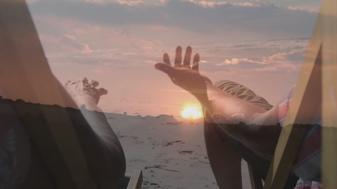 Couple holding hands on beach chairs at sunset, with animated health icon and glowing sun rays