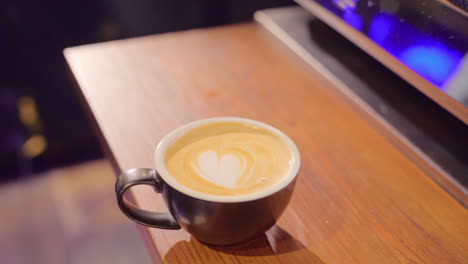 putting a cup of coffee on a wooden table slow motion.