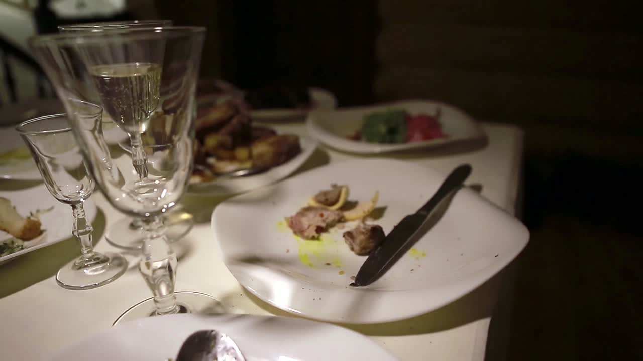 Dirty Dish On Food Table. Wasted food on served festive table after dinner party