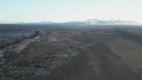 Arid,-rugged-terrain-of-dry-soil,-rocky-formations-and-sparse-vegetation