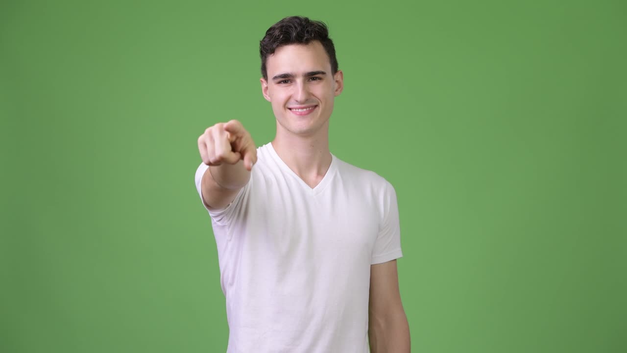 Young happy handsome man pointing at camera