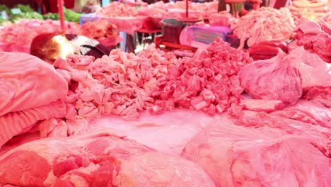 butcher sorting and cutting meat at a busy market.