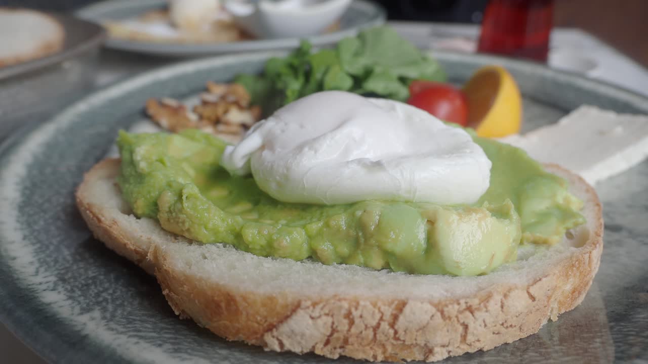 Primo piano di Avocado Toast con uovo in camicia e Feta