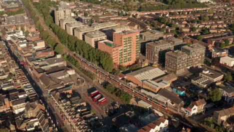 Toma-Aérea-Ascendente-Del-Tren-De-Superficie-De-Londres-Que-Llega-A-La-Estación-De-St-James-Street-Walthamstow