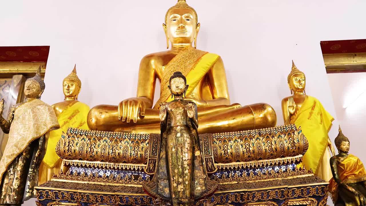 estatuas de oro de buda con ofrendas florales en el templo