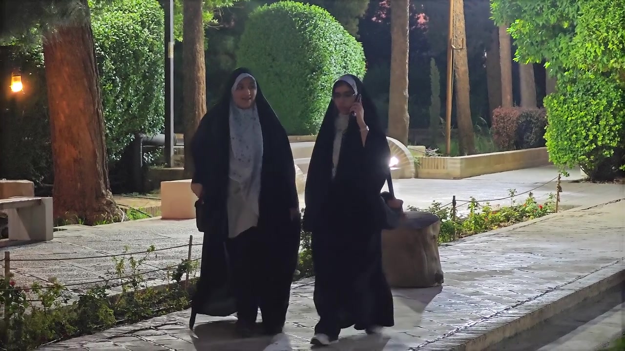 Gece parkta yürüyen çarşaflı iki kadın.