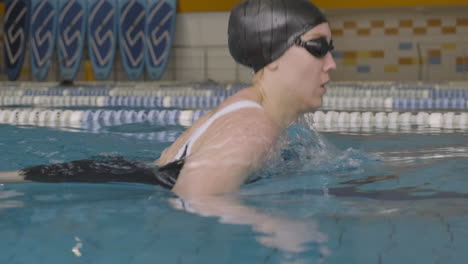 close up of a young swimmer girl swimming concentrated in the indoor pool