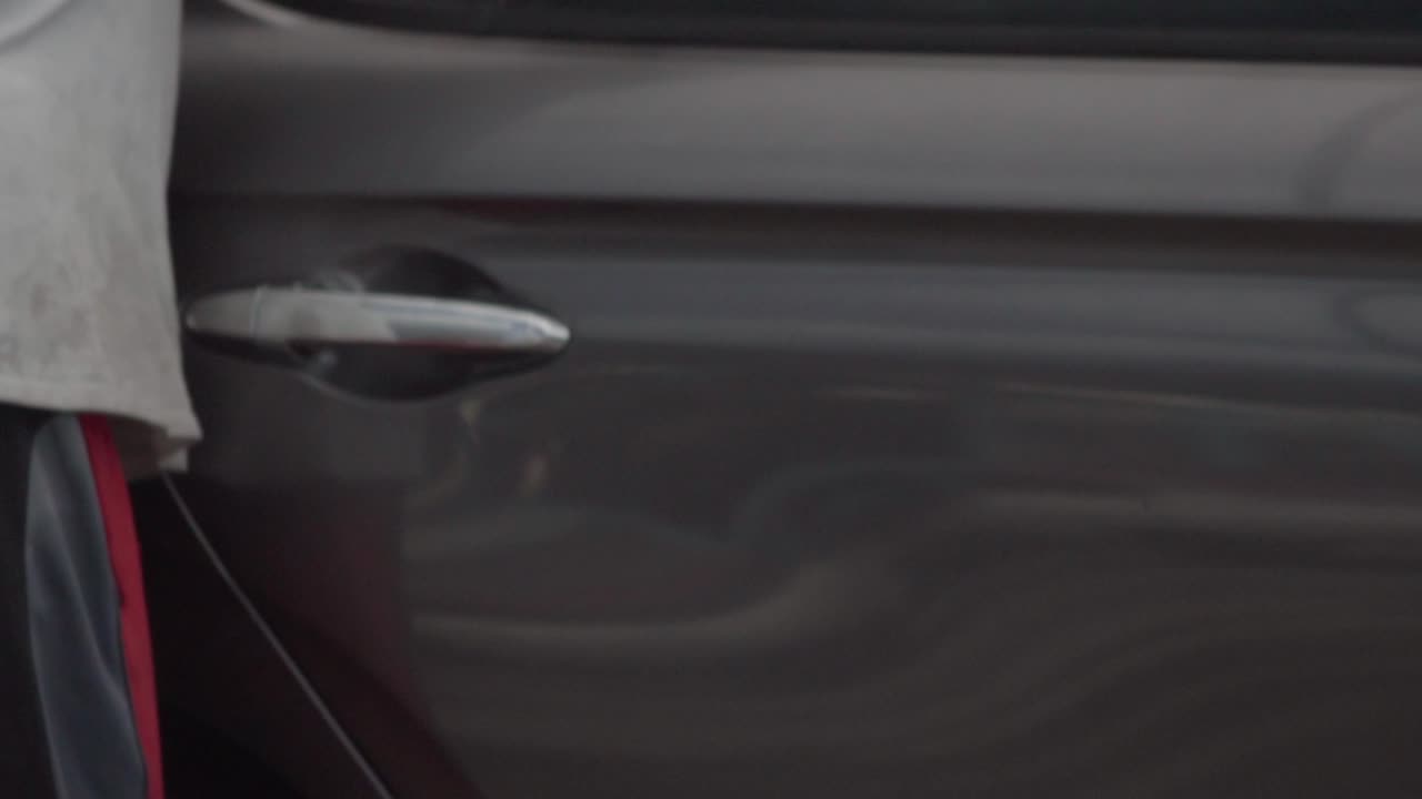 Slow motion video while drying the freshly washed black car.