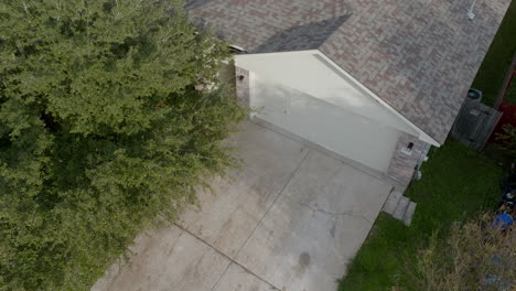 From-an-elevated-vantage-point,-one-can-see-a-residential-property-in-Los-Angeles-that-features-a-house-with-white-doors-and-a-large-tree-located-nearby