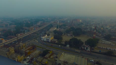 aerial flight over the roads and bridge of urban city, bombay, india, showing a rescue center, a snorkel, and a tower and roof of the houses