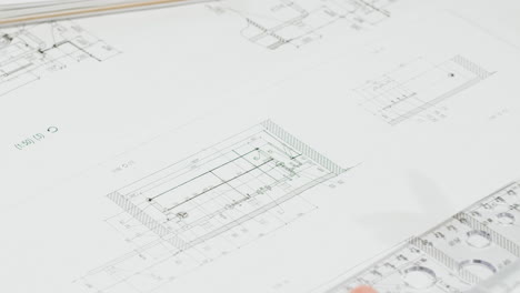 hands drafting architectural blueprints with ruler and pen