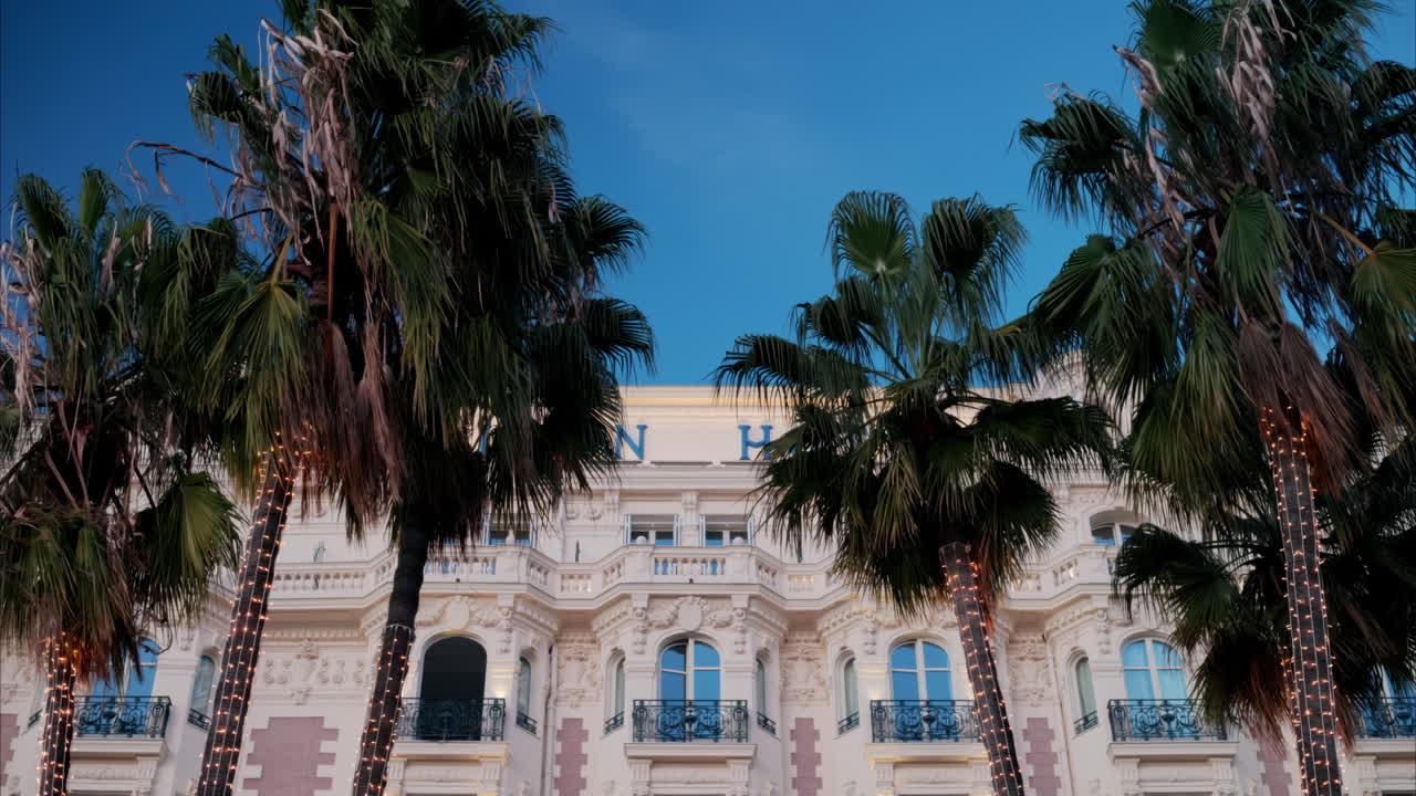 Cannes, France - November 4, 2024: View of palm trees in front of the Carlton Hotel on the coast of the city