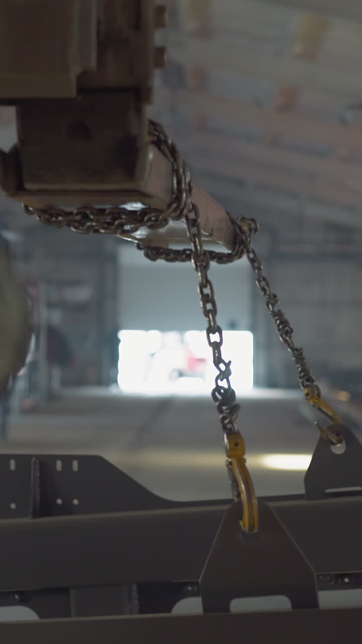 Forklift loader transports metal carcass along plant warehouse view from driver cabin. Truck carries frame detail at manufacturing plant. Driving vehicle