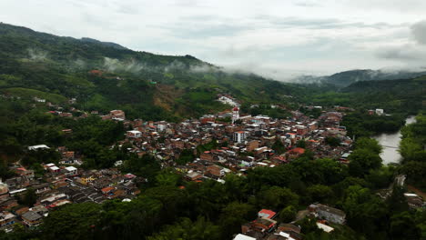 vista aérea dando vueltas alrededor de la ciudad de san rafael, en la nublada antioquia, colombia