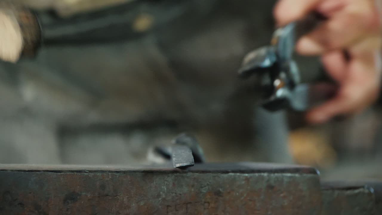 un hombre limpia un producto de metal del herrero a escala en el trabajo