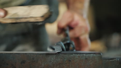 a man cleans a metal product from scale blacksmith at work