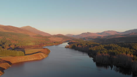 beautiful drone shot in the scottish highlands flying over loch laggan on sunny winters day