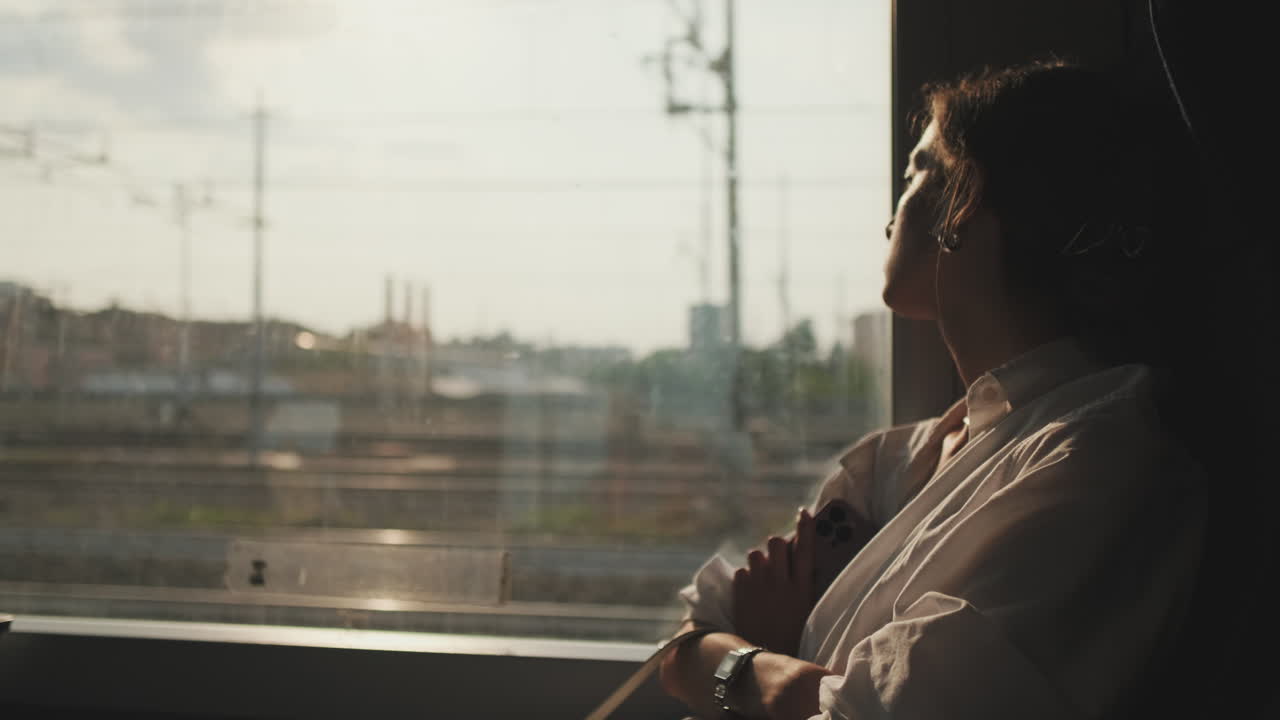 Donna pensierosa che guarda fuori dal finestrino del treno durante un viaggio