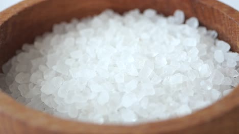 close up of white sea salt in a wooden bowl