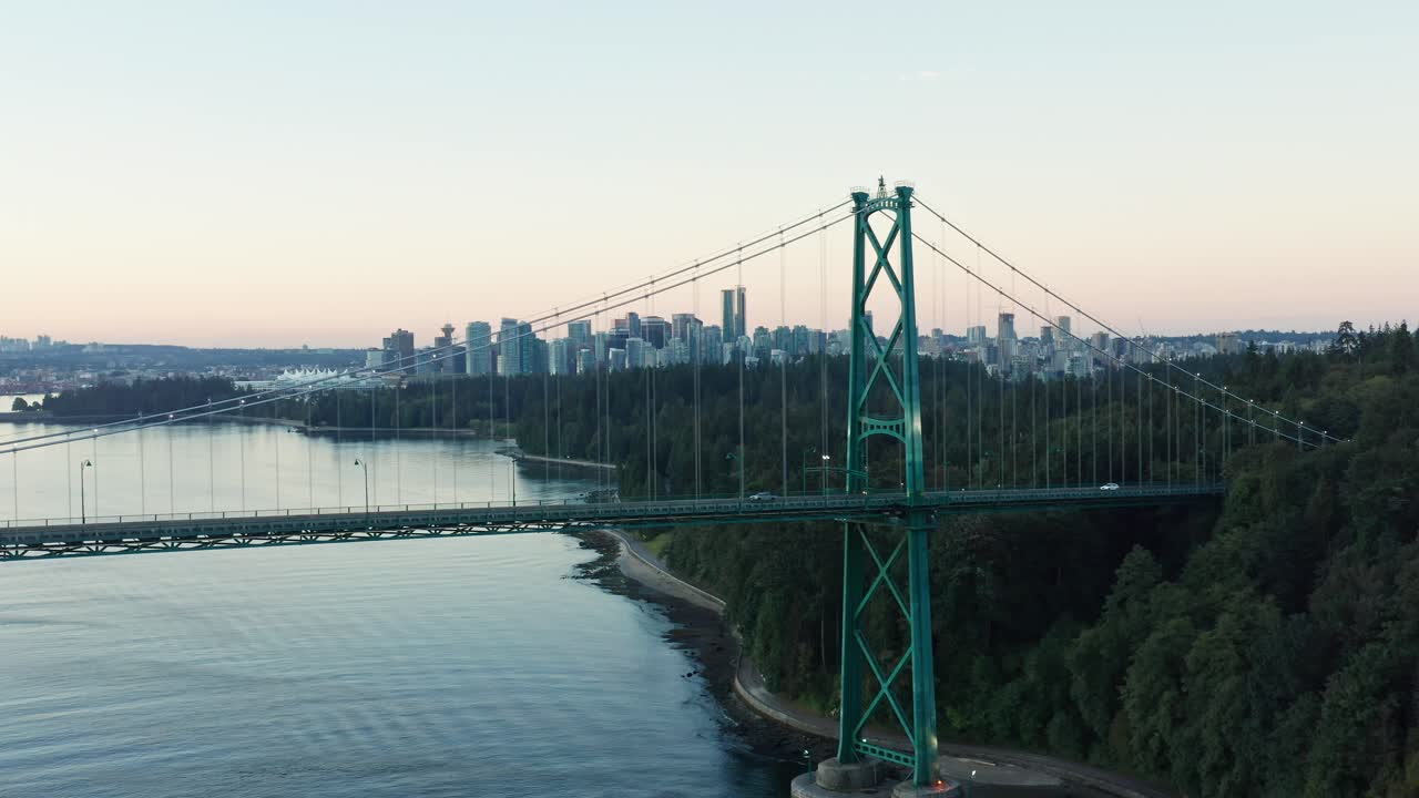 도시 경관을 배경으로 밴쿠버 라이온스 게이트 브리지에서 멀리 날아가는 드론 공중 샷