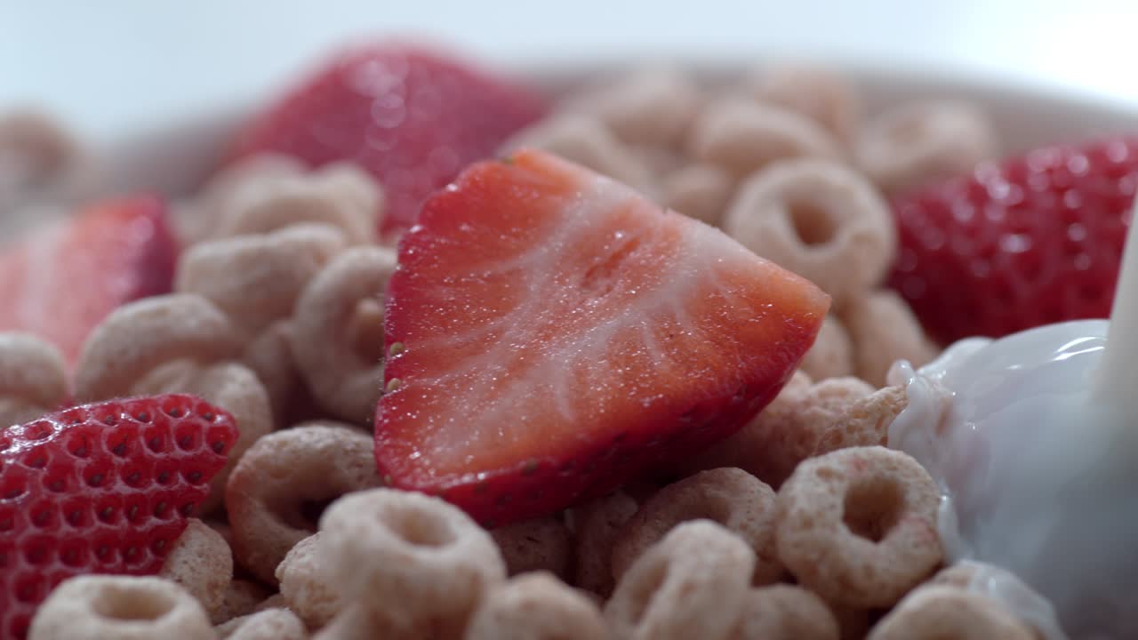 Latte versato su una ciotola di cereali con fragole