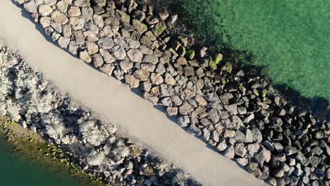 Vuelo-Aéreo-Sobre-Un-Muelle-De-Piedra-En-Aguas-Turquesas-Claras