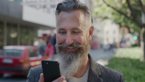 Retrato-De-Un-Hombre-De-Negocios-Exitoso-Usando-Mensajes-De-Texto-De-Teléfonos-Inteligentes-Sonriendo-Disfrutando-De-La-Comunicación-Por-Teléfono-Móvil-Satisfacción-Hombre-Caucásico-Maduro-Barba-Elegante