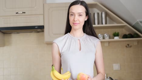 a young woman holds an apple and bananas in her hands a young woman holds an apple and bananas in her hands the concept of vegetarianism fruit diet followup with a figure weight loss