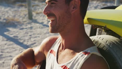 feliz hombre caucásico sentado al lado de la playa buggy por el mar tocando la guitarra
