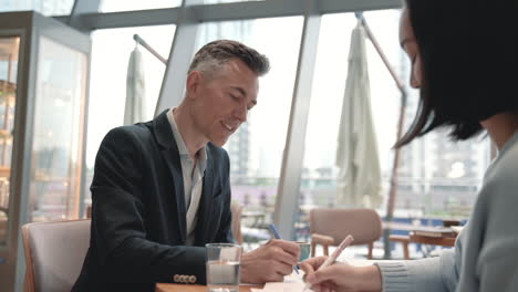 a business man has a meeting with an unrecognizable woman in a cafeteria 3