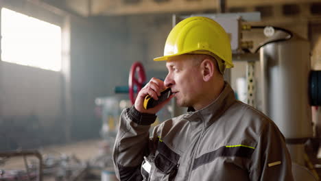 Mann-Mit-Gelbem-Schutzhelm-In-Der-Fabrik