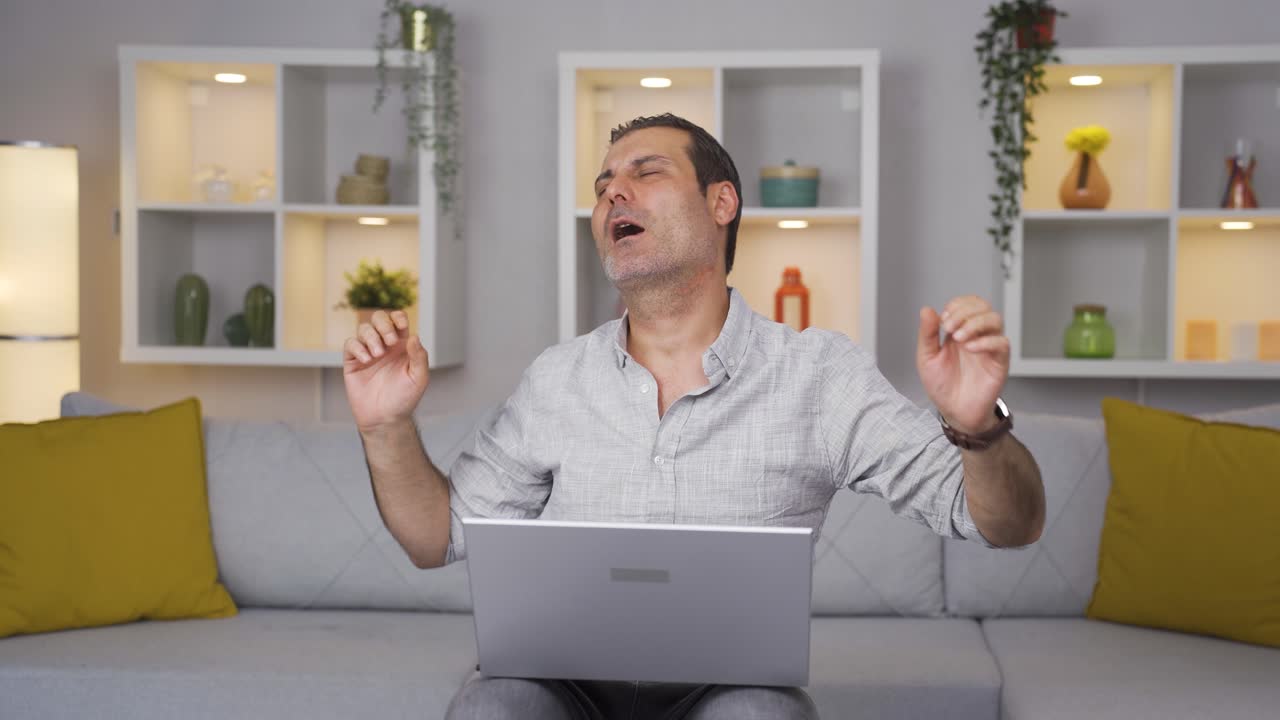 el hombre que mira la computadora portátil está feliz y bailando.