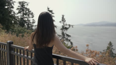 young asian girl in great mood enjoying view at prospect point and looks to the camera, slowmo